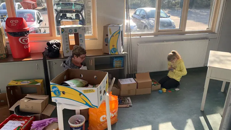 Vrijwilligers sorteren gedoneerde spullen in het clubhuis voor de jubileumverbouwing.