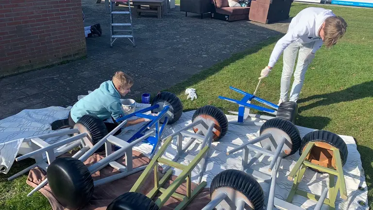 Jongens-C schilderen barkrukken in de CSV-clubkleuren tijdens de klusdag voor het jubileum.