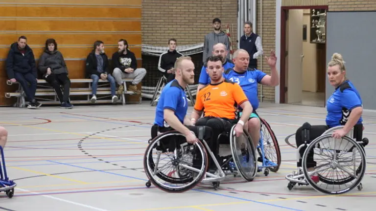 Rolstoelhandbalspelers van CSV-1 en CSV-2 in duel om de bal tijdens de derby.