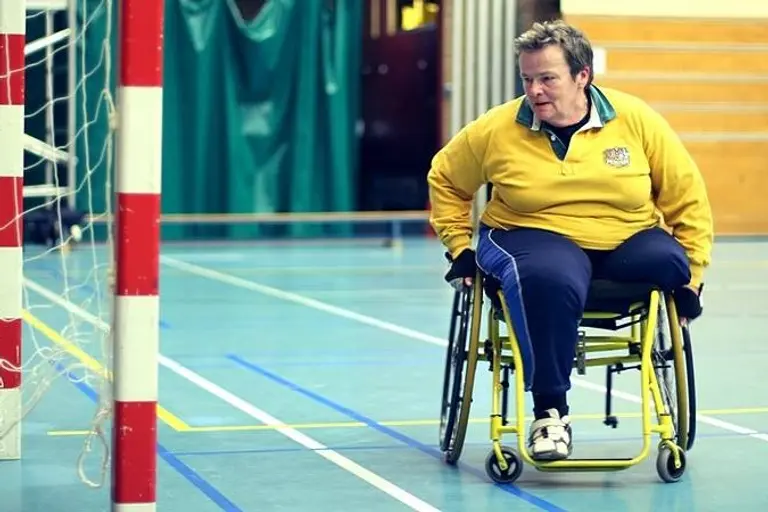 Ada Stam in een handbalrolstoel in de zaal