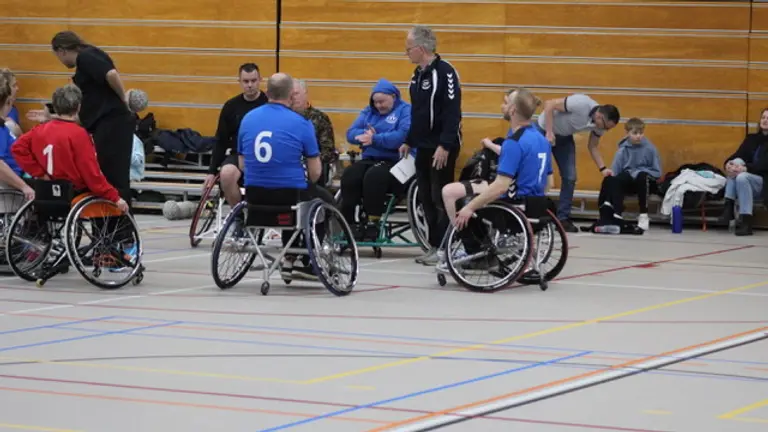 Spelers van CSV-2 in blauw overleggen met de scheidsrechter tijdens de derby.