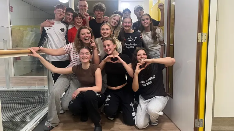Groepsfoto van de MB2-speelsters die harten maken met hun handen na afloop van het toernooi.